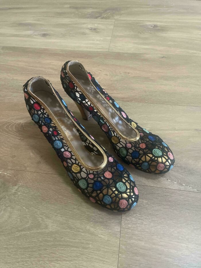 Colorful embroidered high heels with circular patterns, a unique thrift store find on a wooden floor.
