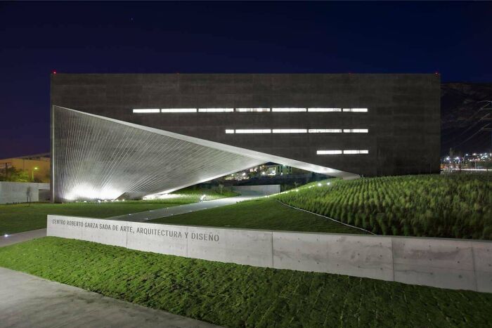 Modern evil building with angular design and dramatic lighting at night, resembling structures from horror movies.