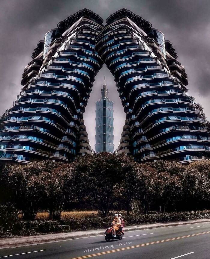 Futuristic evil buildings with dark atmosphere framing a skyscraper, evoking a horror movie setting on a cloudy day.