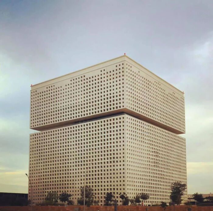 Massive evil building with grid-like windows, appearing eerie and resembling structures from horror movies.