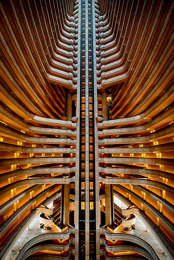 Interior view of an eerie building with symmetrical balconies and glowing lights, evoking evil buildings from horror movies.