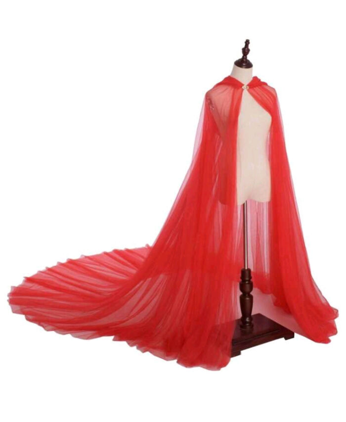 Red bridal cape with long train displayed on dress form, highlighting bold wedding fashion for brides and grooms.