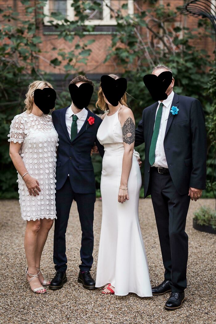Group photo of brides, grooms, and wedding guests posing outdoors at a formal wedding event.
