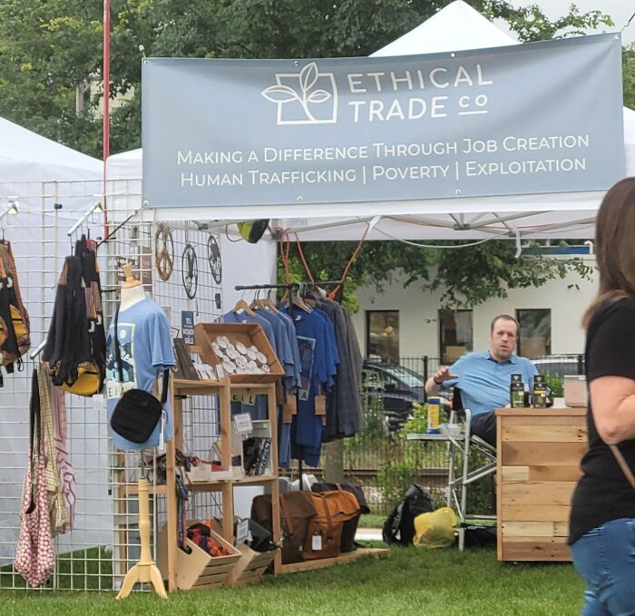 Outdoor market stall with ethical trade products promoting job creation and fighting human trafficking and poverty.
