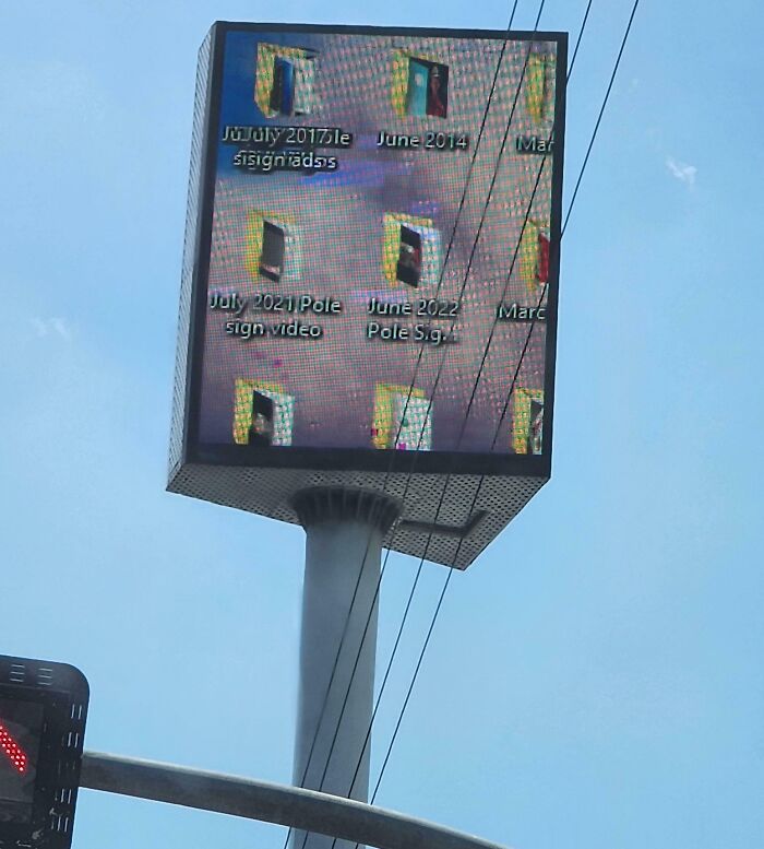 Digital billboard showing a computer desktop screen with folders, illustrating a funny advertising fail.