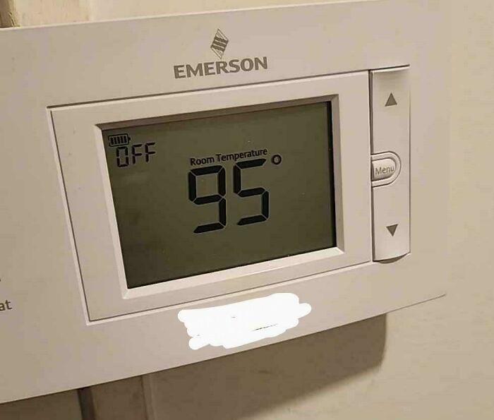 Thermostat display showing room temperature at 95 degrees, illustrating the extreme heatwaves causing a hot mess worldwide.