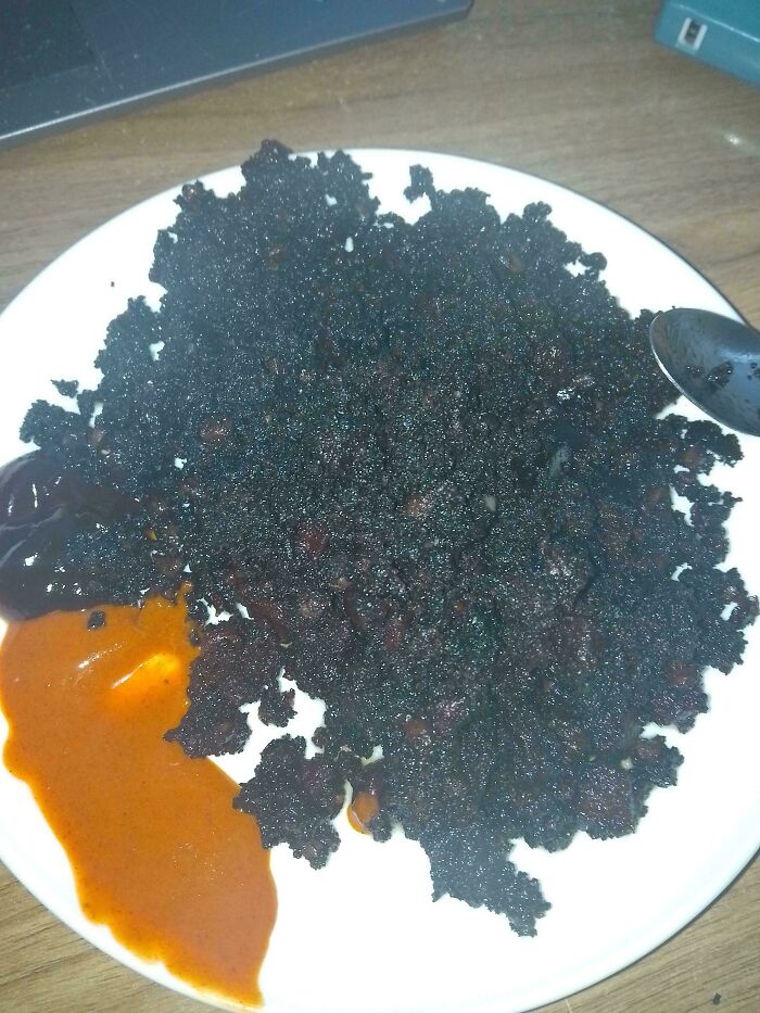 Burnt crispy food on a white plate served with two types of sauces, showcasing one of the dishes that are just stupid.