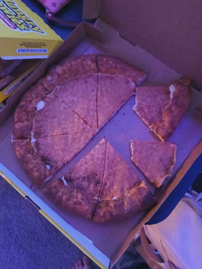 Pizza resembling a giant cinnamon graham cracker in a box, one slice broken off, showcasing unusual dish creativity.
