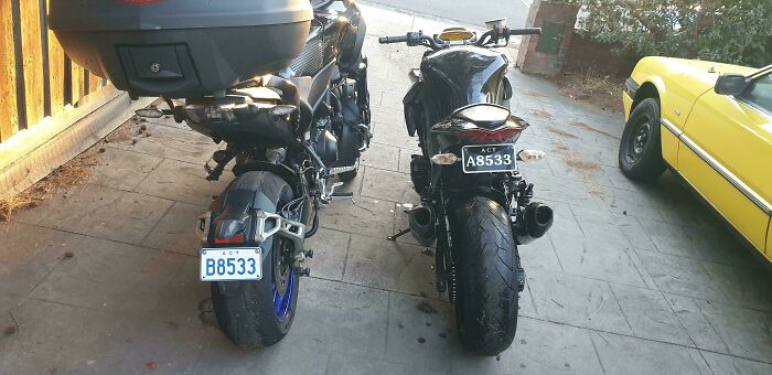 Two motorcycles parked side by side with almost identical license plate numbers, showcasing wild coincidences.