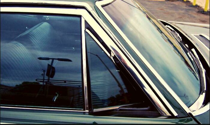 Close-up of a vintage car window and chrome trim, one of the things that make people who recognize it feel very old.