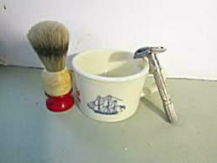 Vintage shaving brush, ceramic mug, and safety razor set, classic items that make people who recognize them feel very old.
