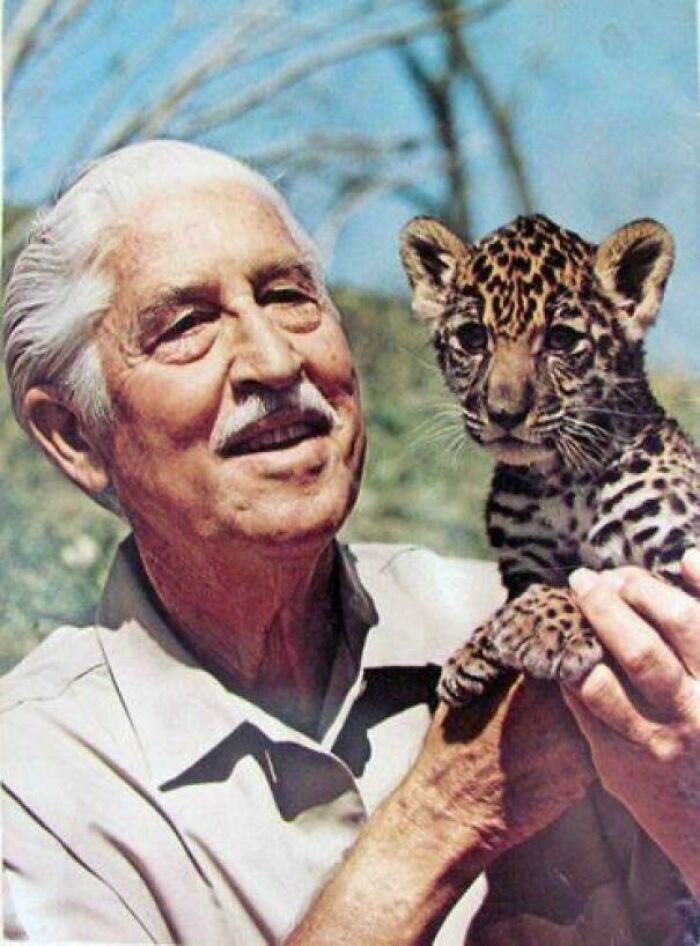 Elderly man holding a young leopard cub outdoors, a nostalgic image that makes people who recognize it feel very old.