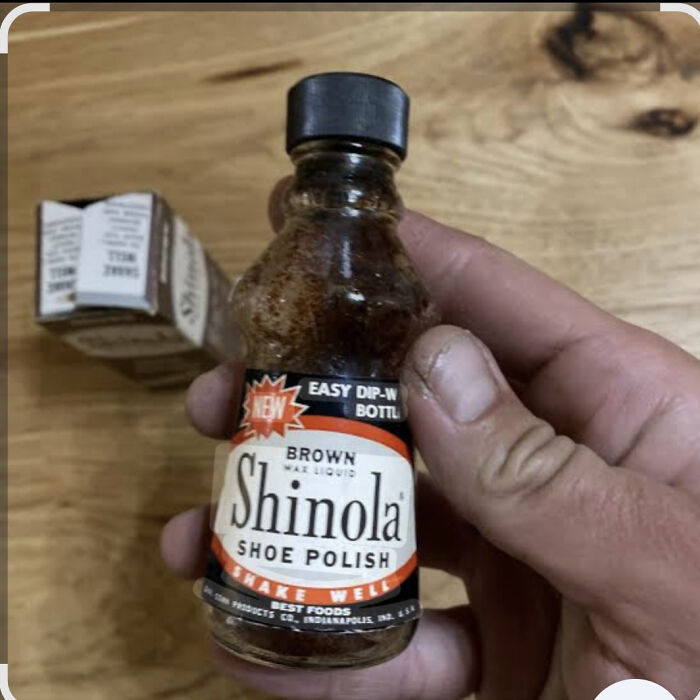 Old-fashioned Shinola shoe polish bottle held in hand, a nostalgic item that makes people feel very old.
