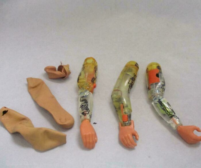 Vintage toy robot arms and worn stockings laid out on a surface, triggering nostalgia for those who recognize them.