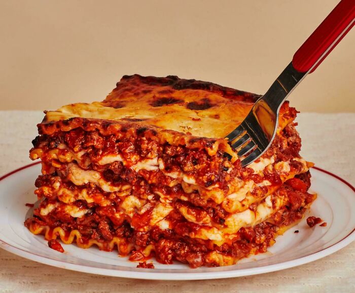 Classic homemade lasagna slice with rich meat sauce and melted cheese, a comfort food that makes people feel very old.