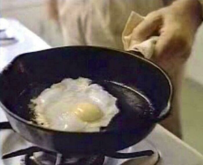 Cast iron skillet frying an egg on a stovetop, a classic item that makes people who recognize it feel very old.