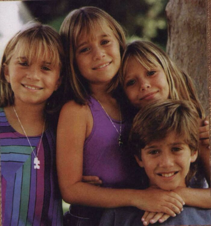 Group of children smiling wearing 90s nostalgic style clothes outdoors