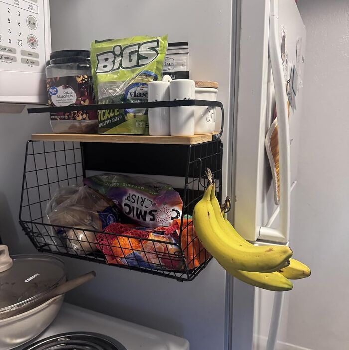 Kitchen storage basket and banana hanger mounted on fridge, showcasing clever products to organize chaotic home corners efficiently.