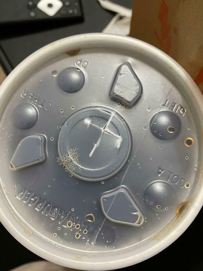 Plastic soda cup lid with unevenly placed ice cubes, a detail likely to annoy people with OCD tendencies.
