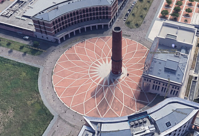Aerial view of a circular plaza with a tall chimney in the center, illustrating imperfect things that annoy people.