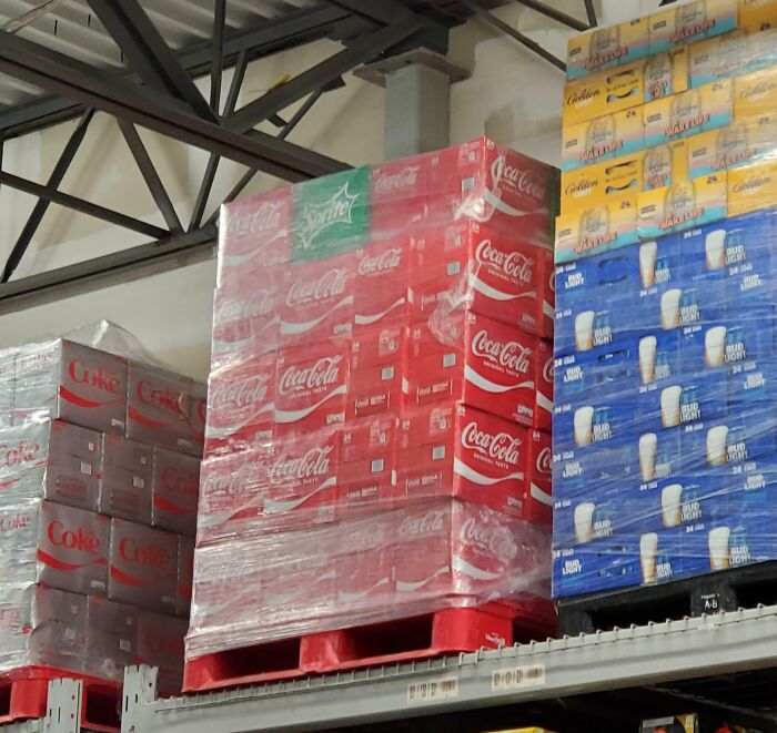 Stacks of soda and beer pallets on shelves in a warehouse, showing imperfect alignment that may bother people with OCD.