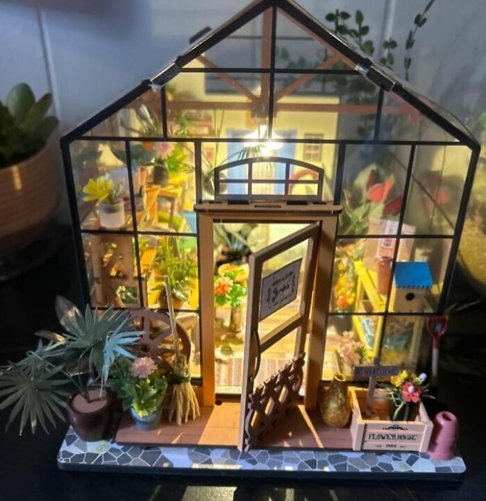 Miniature greenhouse with detailed plants and gardening tools, a creative hobby to try when offline.