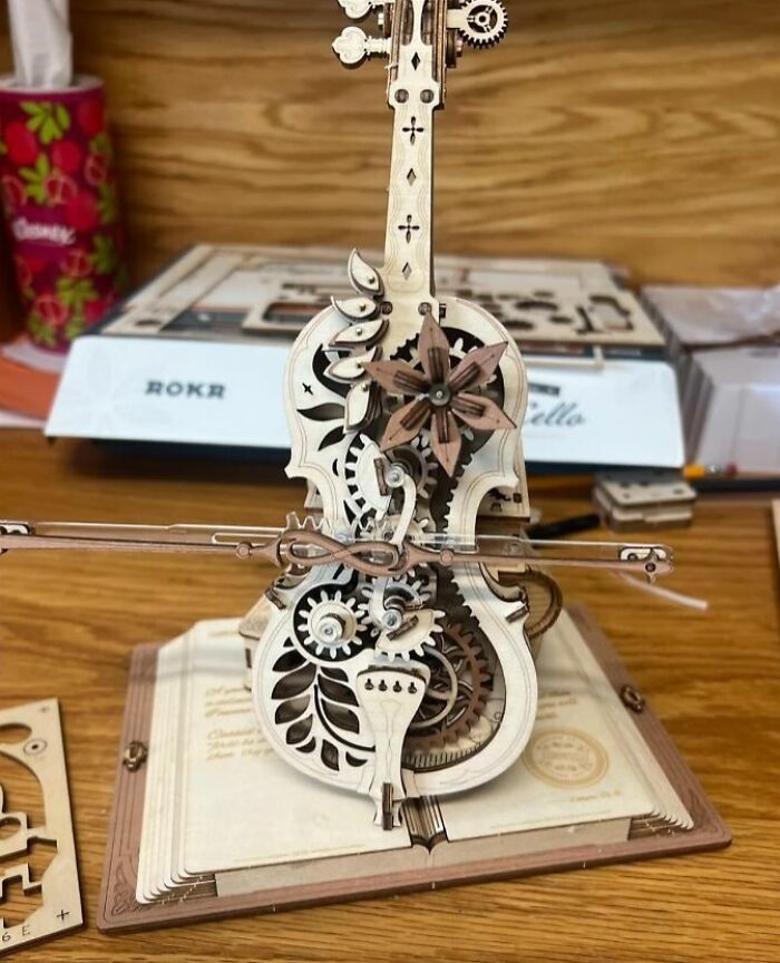Intricate wooden mechanical model of a violin with moving gears, a creative hobby to try when bored.