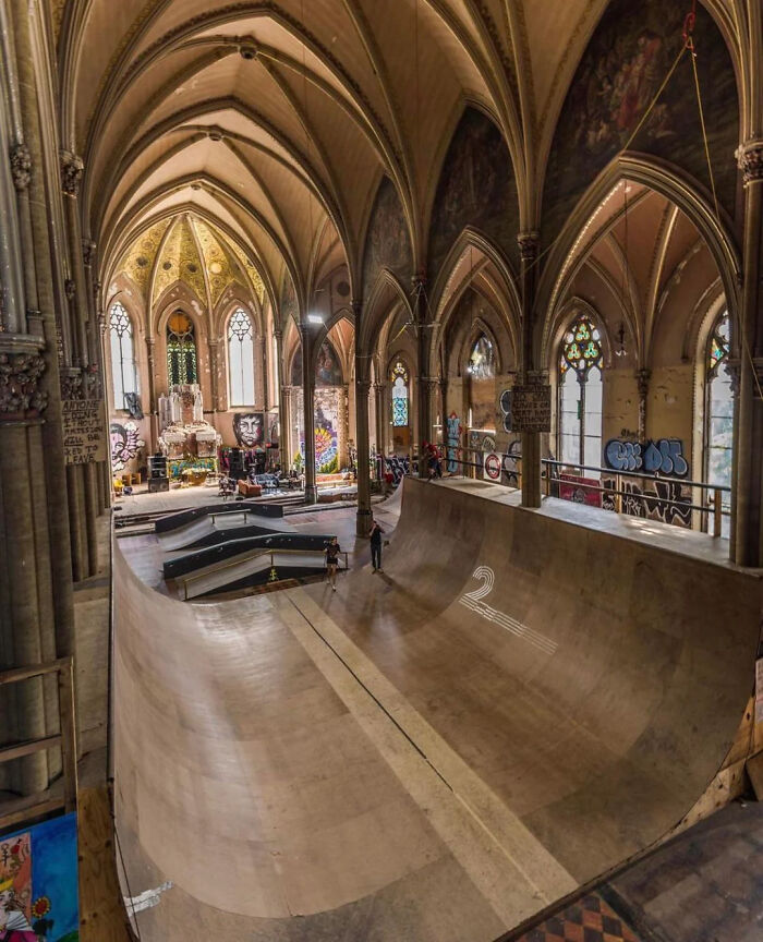 Indoor skatepark inside a historic building with gothic arches, shared by an online group interested in unique facts and pics.