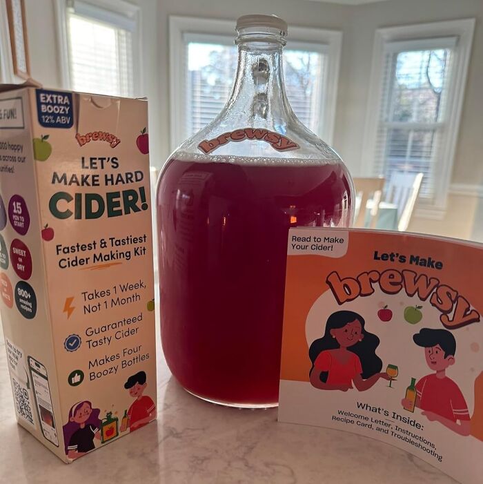 Cider making kit and large bottle of homemade cider on kitchen counter, a creative hobby to try.