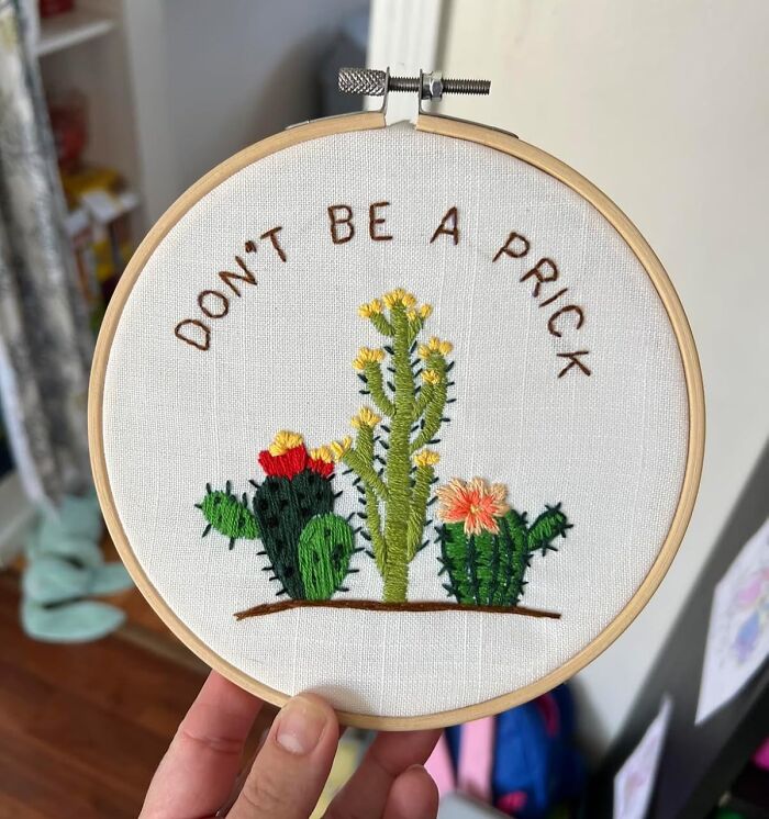 Hand holding embroidery hoop with cactus design and text, a creative hobby to try when exploring new activities.