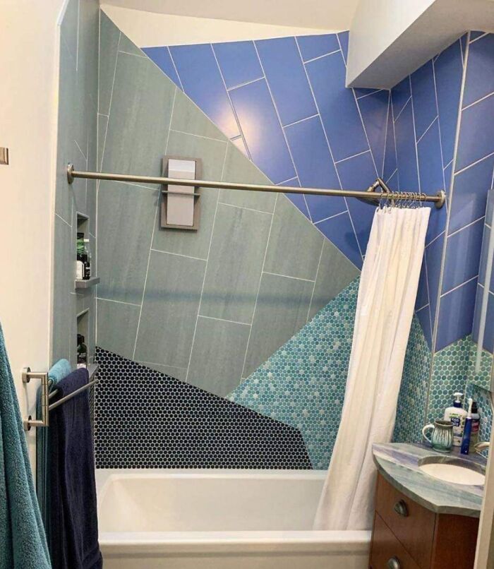 Bathroom with mismatched and imperfect tile patterns on walls, likely annoying for people with OCD due to uneven design.