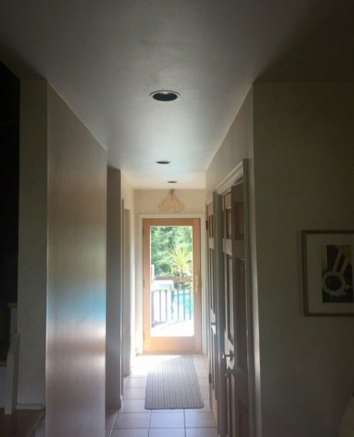 Bright narrow hallway with uneven recessed lights and visible imperfections, illustrating things that annoy people with OCD.