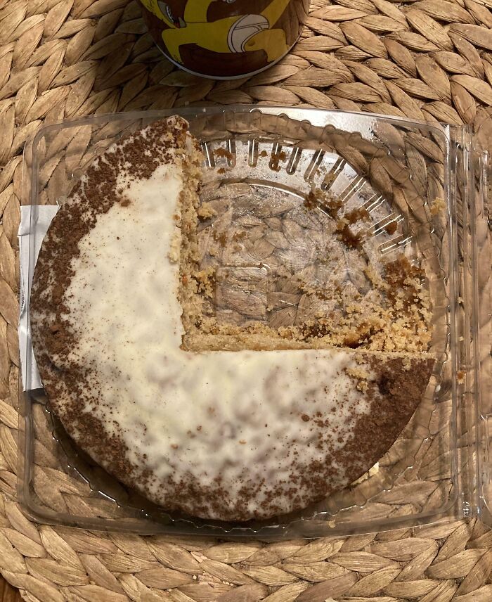 Partially eaten round cake with uneven slice missing in a plastic container, illustrating imperfect things that annoy people.