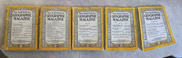 Five vintage National Geographic magazines from the 1950s laid out on a table, capturing the essence of life in that era.