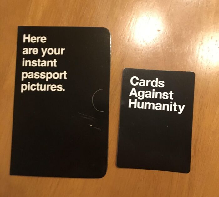 Cards Against Humanity game cards on a wooden table, illustrating a modern contrast to life in the 1950s.