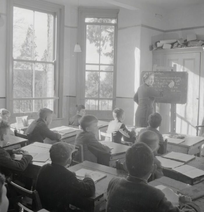 Classroom scene showing students and teacher during World War II in a historic school setting worldwide.