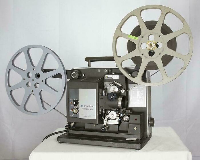 Vintage film projector with reels, evoking nostalgia and memories of old age through classic technology.