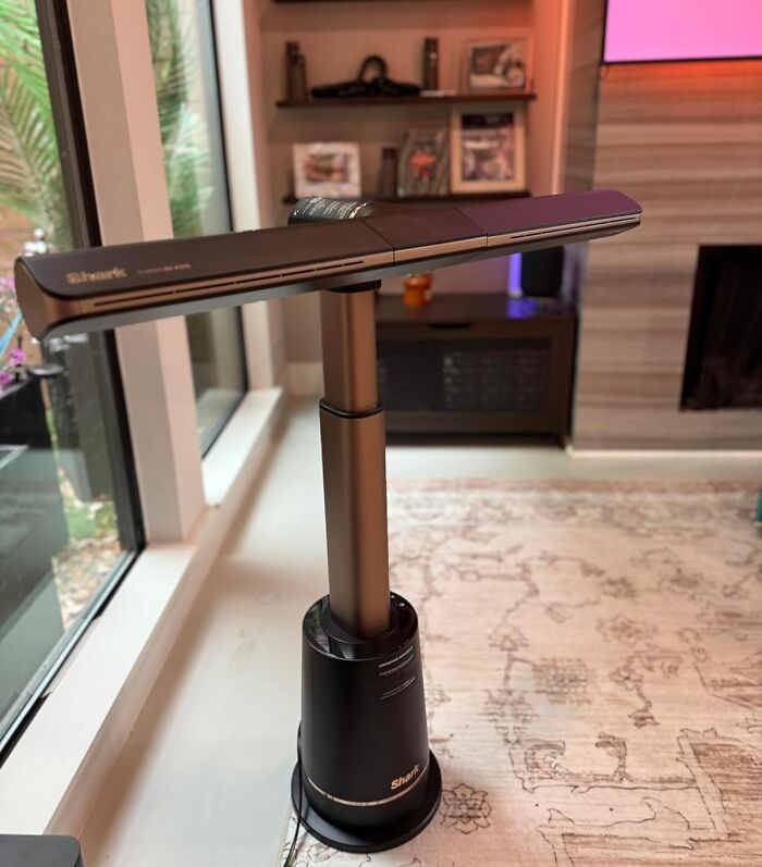 Sleek Shark cleaning tool with modern design standing on a carpeted floor near a window, showcasing peak coolness.