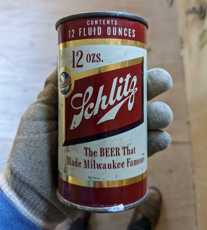 Hand holding a vintage Schlitz beer can from the 1950s, showcasing essence of life and nostalgia from that era.