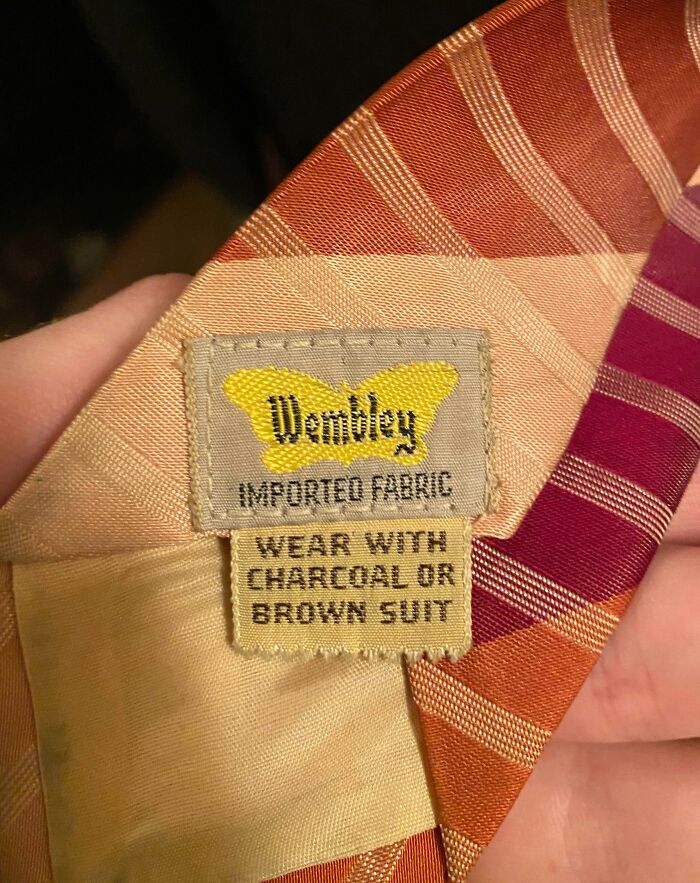 Close-up of a vintage Wembley fabric label on a striped tie, capturing the essence of life in the 1950s fashion.