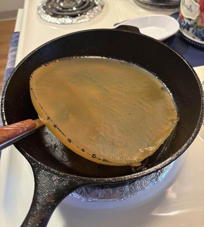 Cast iron skillet with a flexible silicone cooking tool lifting a crepe, showcasing favorite problem solvers under $15.