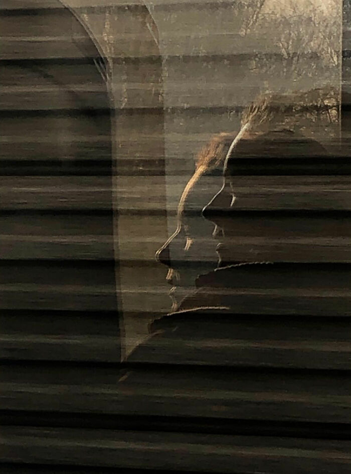 Double exposure effect showing side profile of a person, a funny accidental image taken at the right time and place by street photographer.