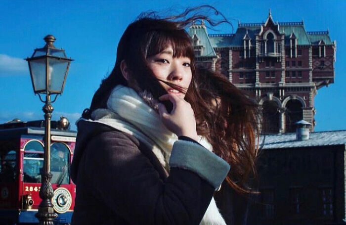 Young woman with flowing hair captured in a funny accidental image by a street photographer in an urban setting.