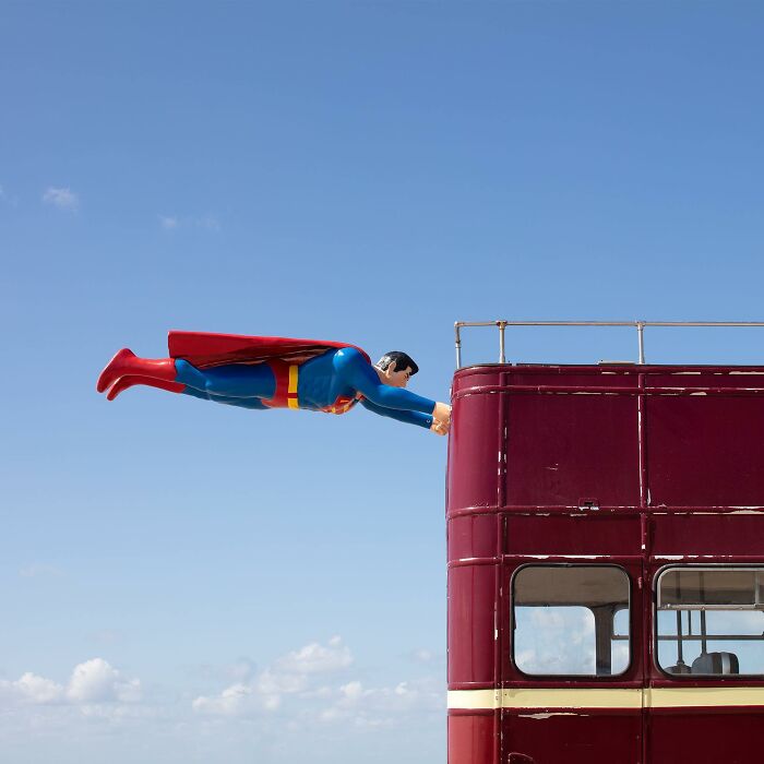 Superman street art installation creatively integrated with a red bus, showcasing clever public spaces interpretation by Frankey.