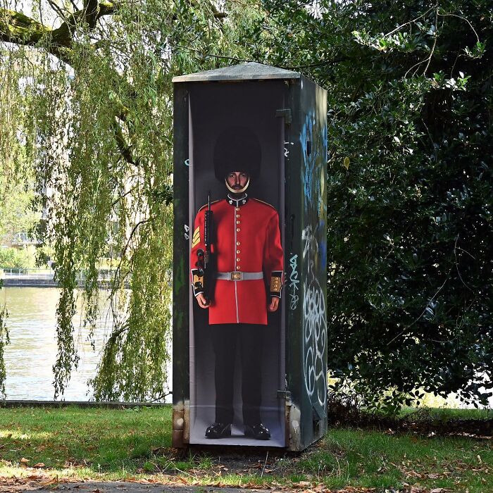 Street art showing a British guard painted on a public utility box in a park as a clever public space interpretation.