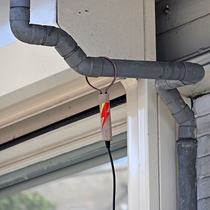 Street art interpretation of a jump rope hanging on a grey metal pipe in a public space by Frankey.