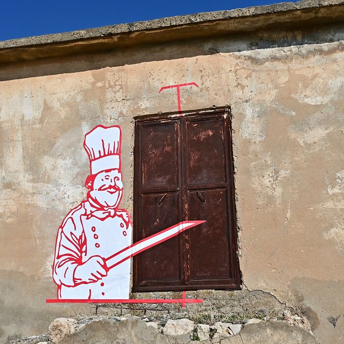 Street art by Frankey creatively transforms a closed brown metal door into a chef holding a large knife.