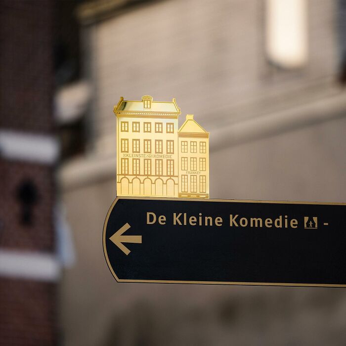 Street art by Frankey featuring clever interpretations of public spaces on a directional sign in an urban setting.