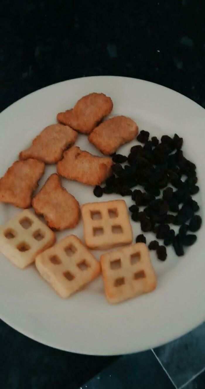 Plate with chicken nuggets, square snacks, and raisins, illustrating funny memes about life in the UK humor.
