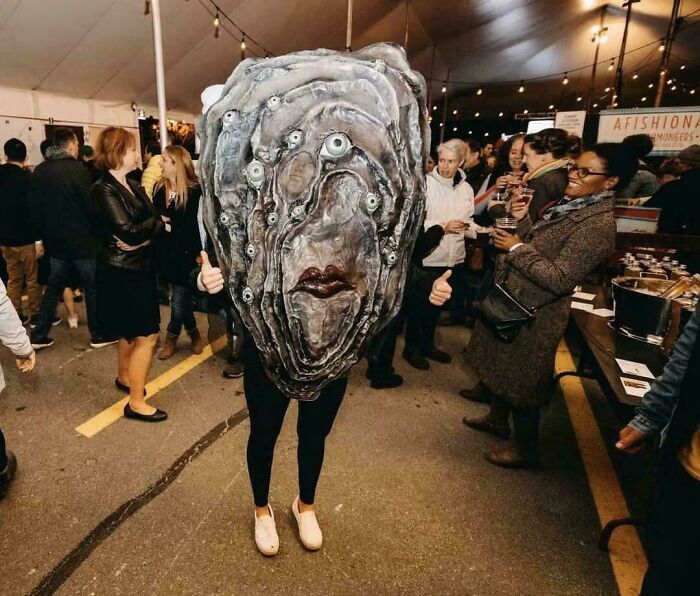 Person wearing an oddly terrifying multi-eyed monster costume at event